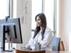 Woman sitting at desk looking at computer screen