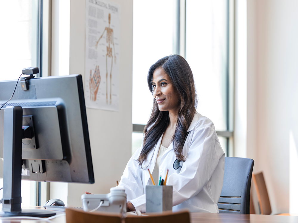 Woman sitting at desk looking at computer screen